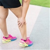 Female athlete grabbing calf muscle in pain from PAES & CECS.